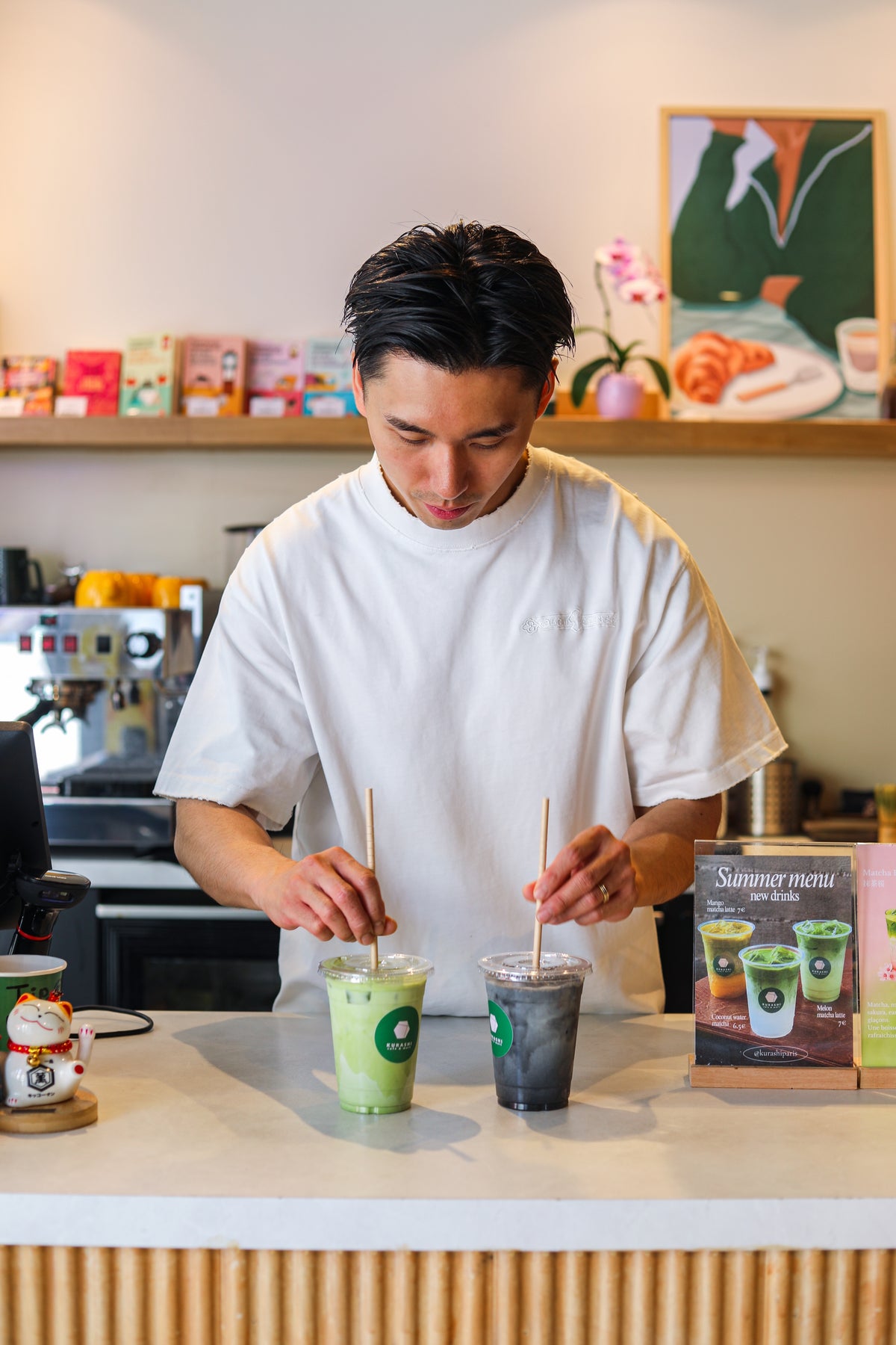 Deux matcha glacés préparés au comptoir, devant la carte des nouvelles boissons